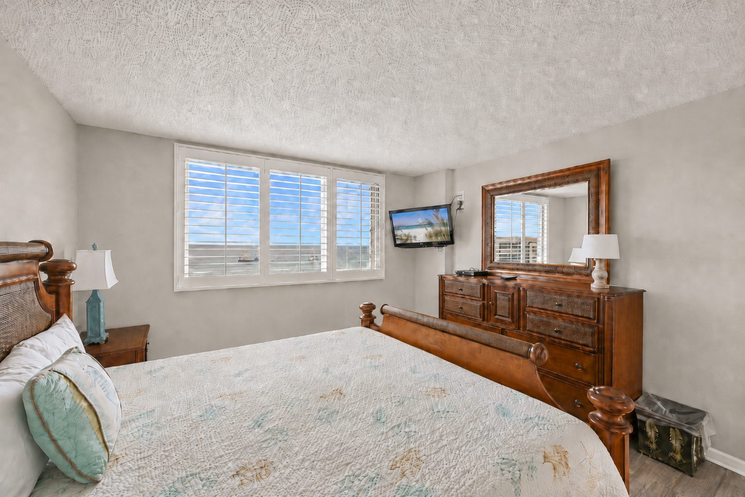 Master bedroom dresser, TV and shuttered windows facing the Gulf